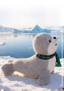 Détail de la peluche otarie grise de 23cm avec écharpe verte sur fond polaire
