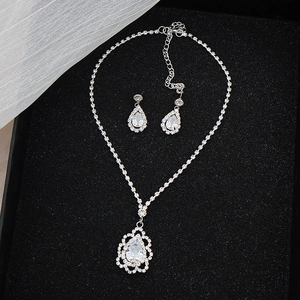 Close-up of bridal jewelry set with pear-cut zircon necklace and earrings in silver box