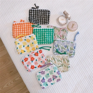 Detailed flat lay of floral cotton pouches with colorful patterns and wrist straps