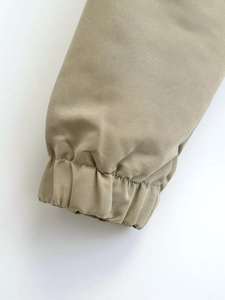 Detailed close-up of khaki jacket elastic cuffs with premium woven fabric texture