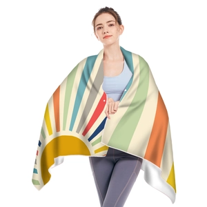 Close-up of microfiber beach towel featuring vibrant sun and colorful stripe patterns