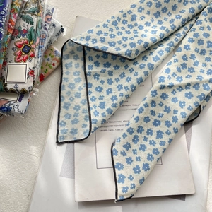 Detail of blue floral cotton linen scarf with black piping on aesthetic book