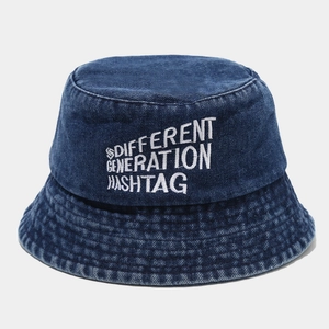 Gros plan de la broderie blanche sur un chapeau bob en denim délavé bleu foncé tendance