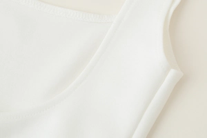 Détail montrant la texture en maille blanche et les coutures renforcées d'un débardeur