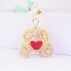 Détail d'un porte-clés carrosse doré avec cœur rouge et strass brillants étincelants