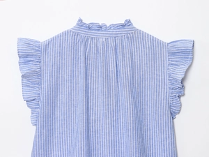 Détail du col montant volanté et des manches papillon sur chemise en coton à rayures