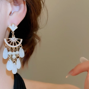 Detail of vintage style ginkgo leaf earrings with pearls and water drop tassels on model