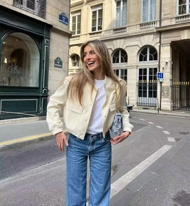 Detail of a beige stand-collar jacket with large pockets on a street fashion model