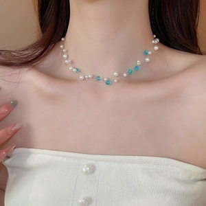 Detail of double-layer pearl necklace with sky blue crystal beads on invisible wire
