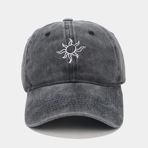 Detailed view of white sun embroidery on dark grey washed cotton baseball cap texture