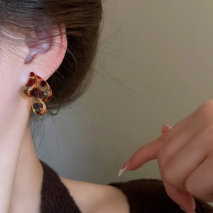 Close-up of leopard print resin earrings in water drop shape worn on model's ear