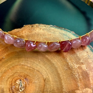 Macro detail of handmade bridal headband with raw pink crystals wrapped in gold wire