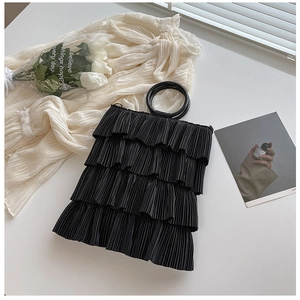 Detail of black pleated tote bag with tiered ruffle design and circular top handle