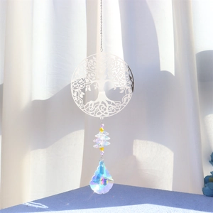 Detailed view of Tree of Life metal pendant with crystal prism creating rainbow light
