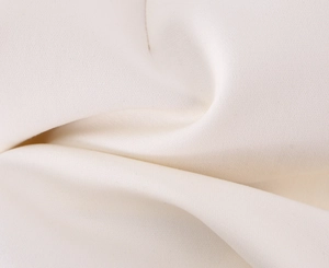 Détail macro du tissu textile blanc montrant une texture tissée fine et des plis doux