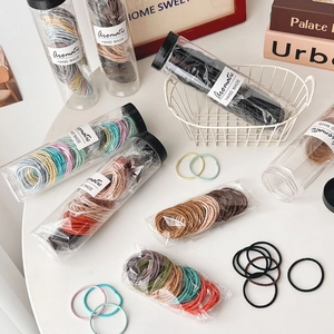 Macro shot of colorful high-elastic spiral hair ties in clear packaging and loose display