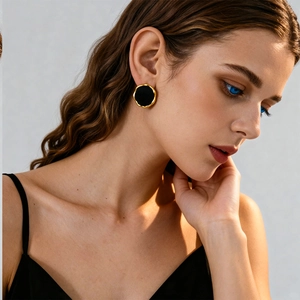 Retro geometric flocked round earrings with gold trim worn by a model in a close-up view