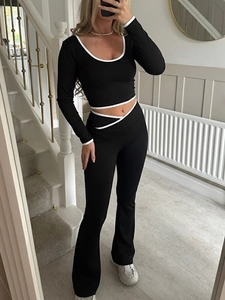 Détail d'un ensemble de yoga Y2K noir avec liseré blanc contrasté et pantalon évasé