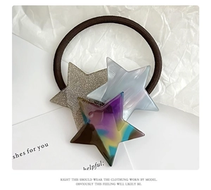 Detail of high-elastic hair tie with marble acrylic and glitter star charms