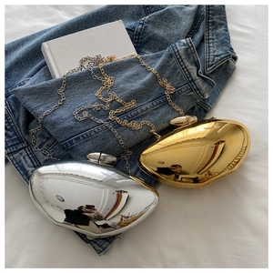 Detail of metallic gold and silver oval acrylic clutch bags with chain straps on denim