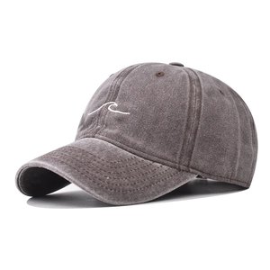 Detailed embroidery of white wave lines on a washed dark gray cotton baseball cap