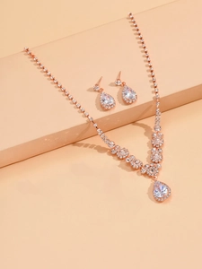 Detail view of rose gold bridal jewelry set featuring sparkling teardrop crystals