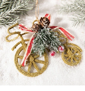 Close-up of golden bicycle Christmas ornament with pine cones and red berries on white snow