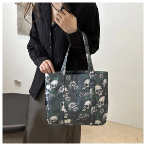 Fashion tote bag with skull and flower print featuring an external pocket and dark base