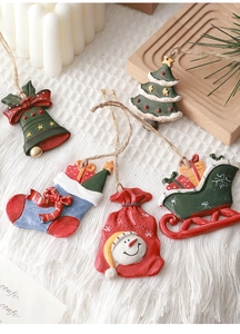 Detail of 5-piece resin Christmas ornaments including snowman and sled on white carpet