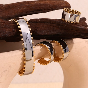 Macro view of two-tone stainless steel jewelry set with silver finish and gold beaded edges