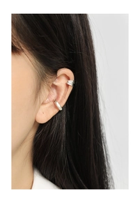 Close-up of silver irregular textured and smooth ear cuffs on a model's ear