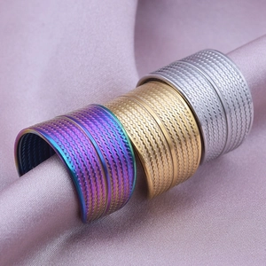 Three wave textured 304 stainless steel rings in rainbow, gold and silver on silk fabric