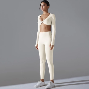 Detail von cremefarbenem Langarm-Crop-Top und High-Waist Yoga-Leggings Set
