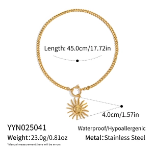 Macro shot of gold stainless steel sun pendant with face detail on 45cm Cuban chain