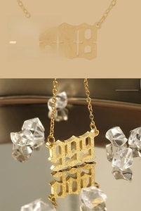 Detailed view of number 999 pendant with gold sand finish and matte texture