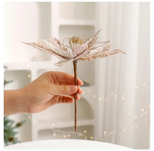 Gros plan d'une fleur de Noël à paillettes champagne doré aux pétales scintillants
