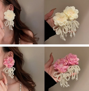Detalle de pendientes de flores con borlas de perlas en crema y rosa suave