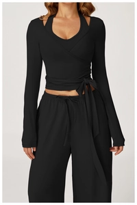 Detail of black yoga wrap top with side tie and high-waisted loose joggers set