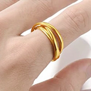Close-up of three interlocking gold stainless steel rings worn on finger