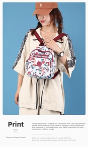 Detail of printed nylon mini backpack with red straps and multiple zipper compartments
