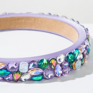Vue détaillée du serre-tête en satin violet orné de cristaux colorés de luxe facettés