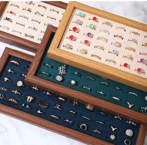 Macro view of walnut wood jewelry display trays with velvet lining for rings and studs
