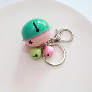 Detailed shot of multi-color cartoon bells with pink and green finish on silver keychain
