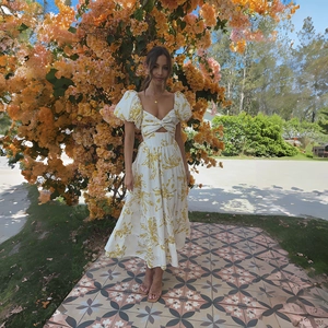 Detailed close-up of puff sleeves and waist cut-out on yellow floral maxi dress