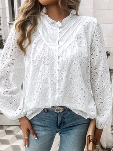 Detail of white eyelet lace blouse featuring V-neck, button placket and lantern sleeves