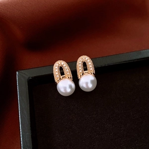 Detail of 18K gold plated hoop earrings with micro-pave diamonds and round white pearls