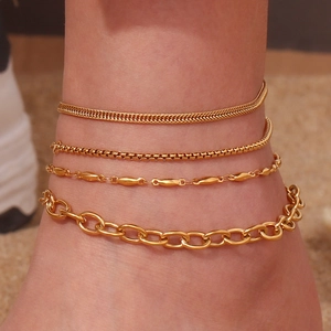 Detail of four layered gold-plated stainless steel anklets including snake and box chains