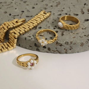 Detailed top view of gold floral rings with zircon and matching stainless steel watch bands