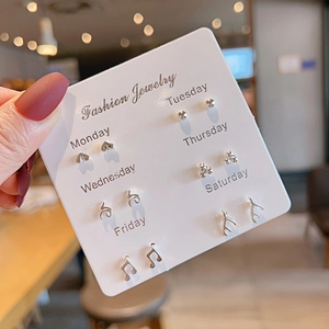Set of six silver stud earrings featuring hearts and notes on a weekly card display
