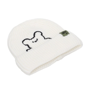 Close-up of white ribbed knit beanie featuring black bear embroidery and green side label